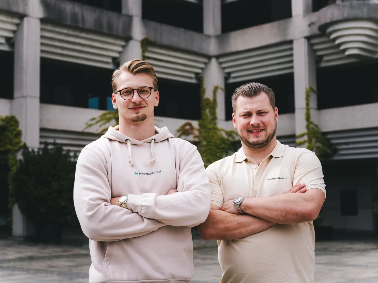 Timo und Nico Haslberger mit verschränkten Armen vor einem Betonbau in Linz